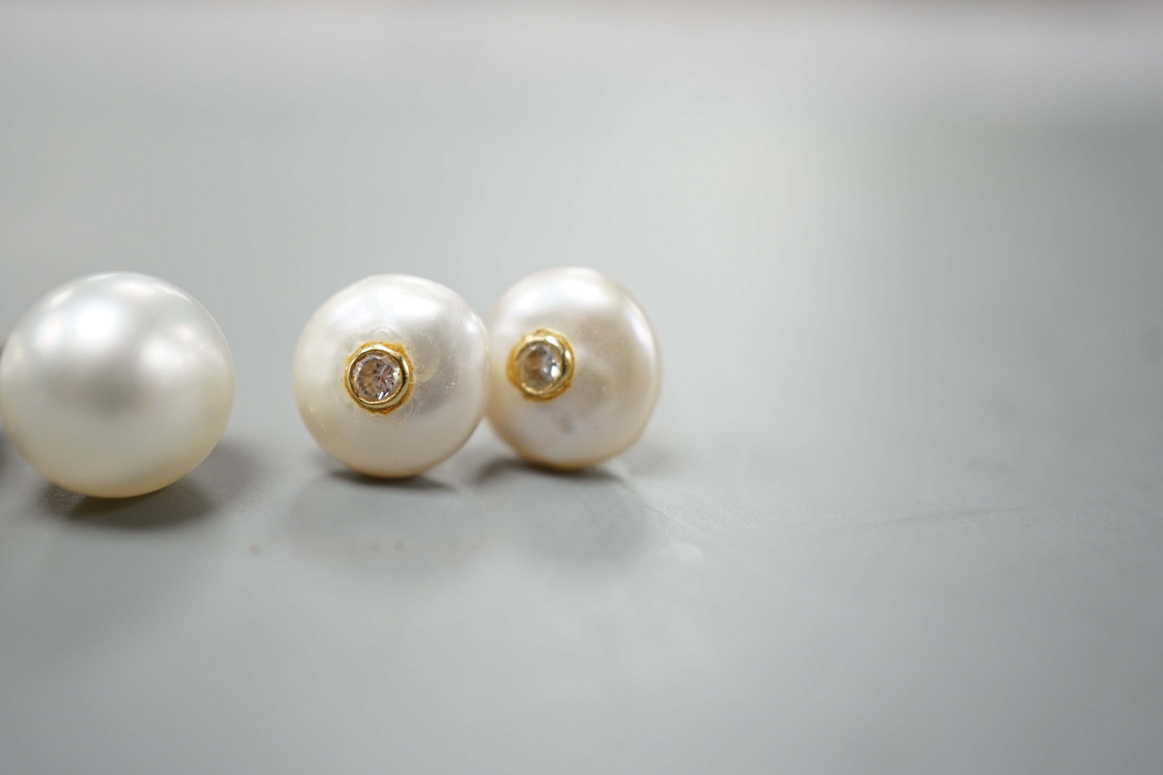 A pair of 18ct and cultured pear ear studs, a pair 9ct gold and mabe pearl ear studs and a pair of 18k, cultured pearl and diamond set ear studs (all lacking butterflies).